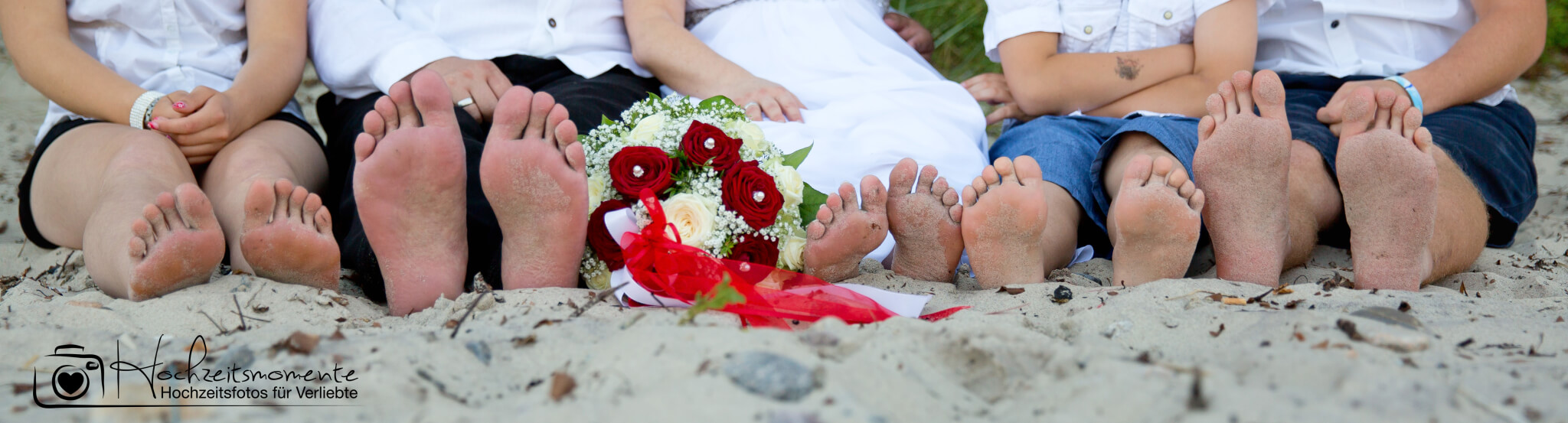 Füße von fünf Personen am Ostsee-Strand