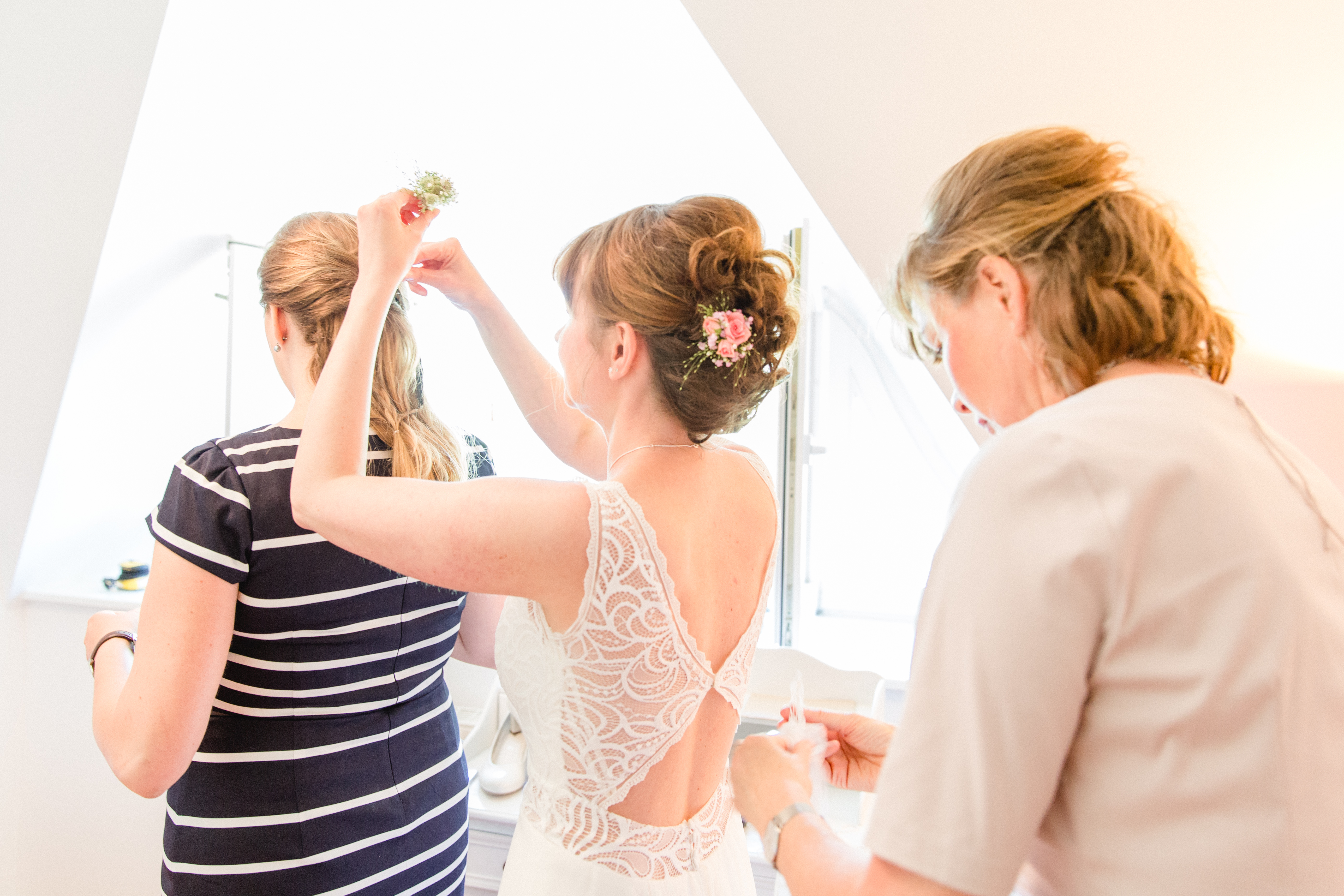 Mädels helfen sich gegenseitig beim fertigmachen für die Hochzeit.