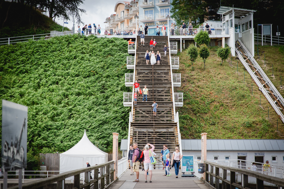 Braut kommt die Treppe vorm Standesamt Sellin runter gelaufen.