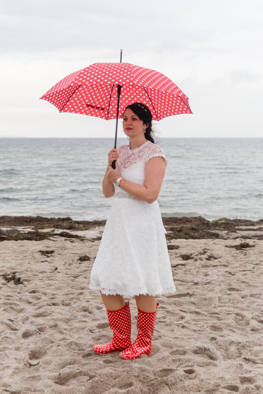 Braut beim Fotoshooting mit Regenschirm.