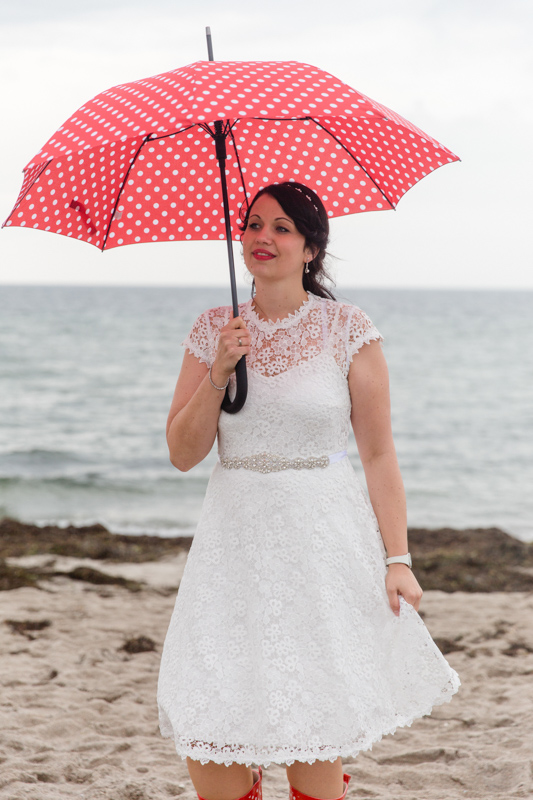Braut mit Regenschirm an der Ostsee.