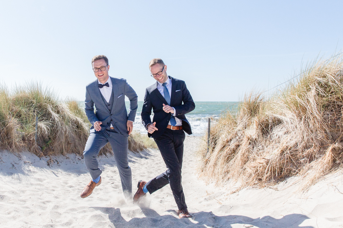 Hochzeitsfotos zweier Männer am Strand.