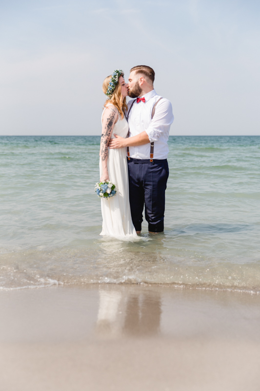 Brautpaar steht beim Shooting in der Ostsee.