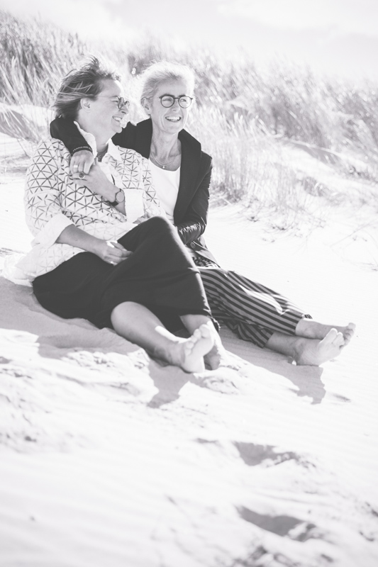 Kuschelnde Frauen am Strand.