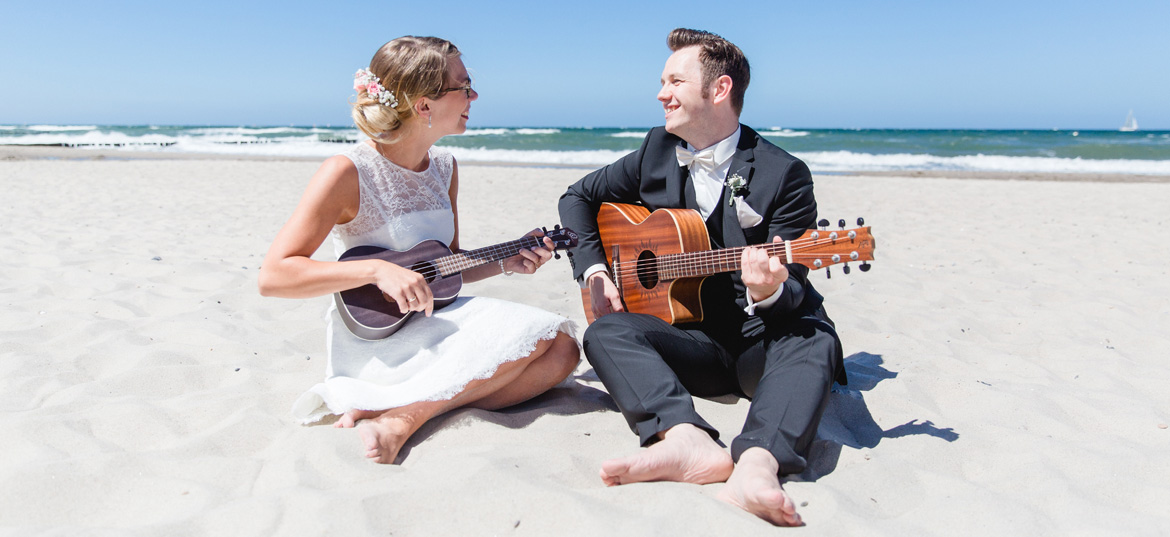 Brautpaar musiziert gemeinsam am Strand von Kühlungsborn.