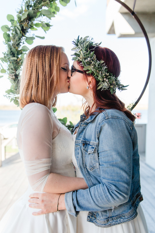 Kuss zweier Frauen bei Hochzeit.