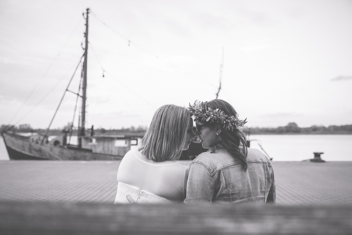 Schwarz weußes Hochzeitsfoto mit Schiff im Hintergrund.