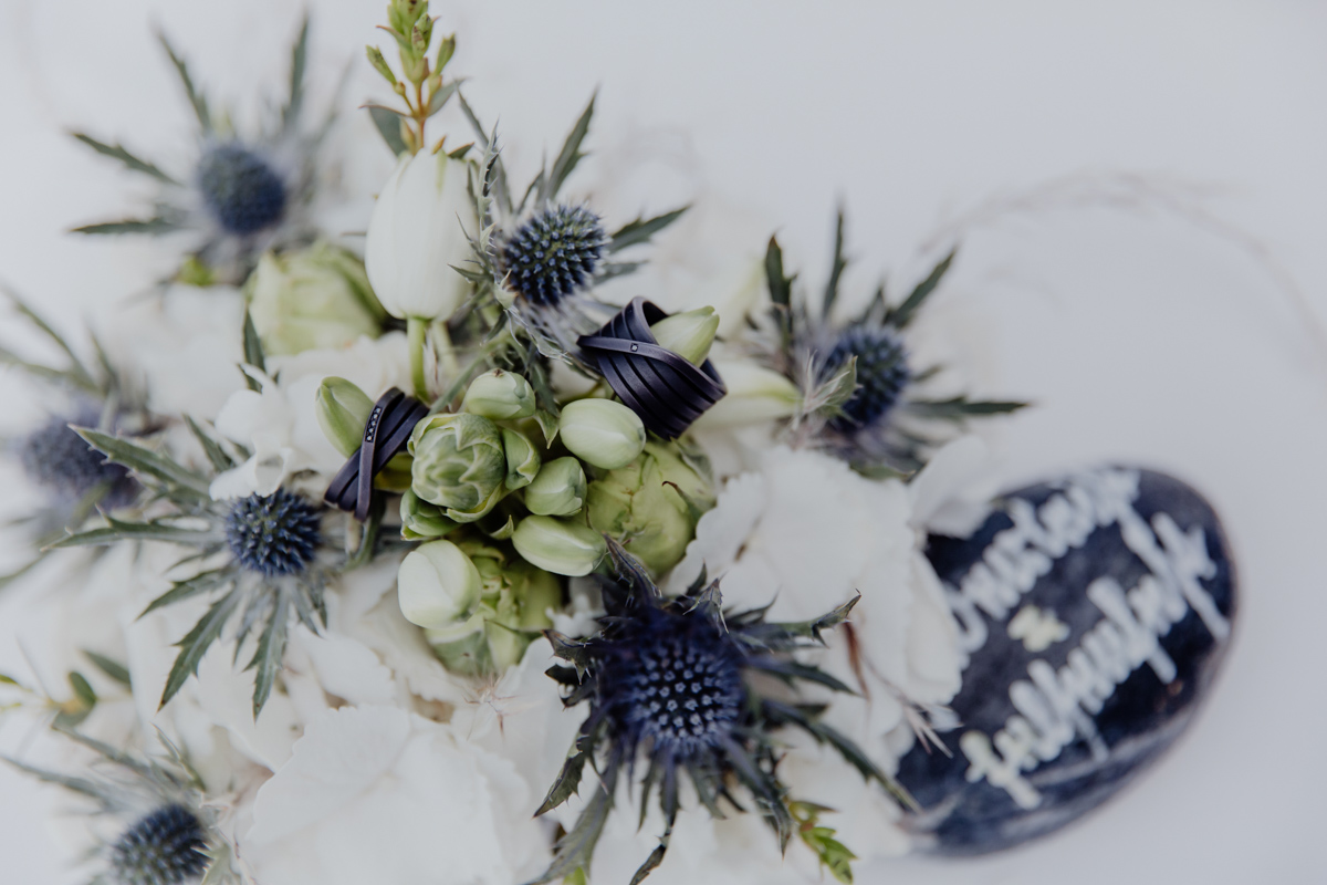 Detailaufnahme der Eheringe auf Blumen.