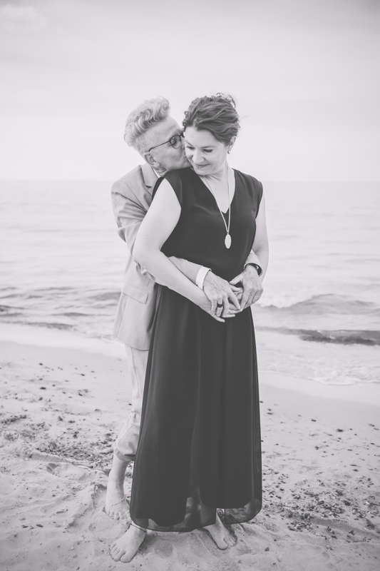 Hochzeitsfoto eines kuschelnden Brautpaares am Ostseestrand.