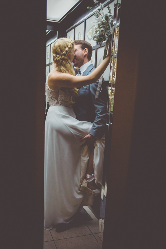 Brautpaar küsst sich im Fahrstuhl.