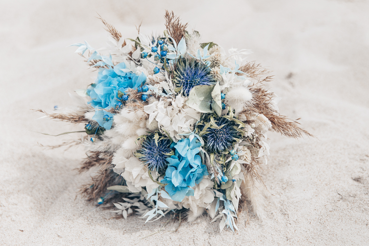 Standesamtliche Hochzeit zu zweit Rostock 21 Brautstrauß liegt im Sand.